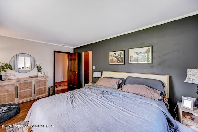 bedroom with hardwood / wood-style floors and ornamental molding