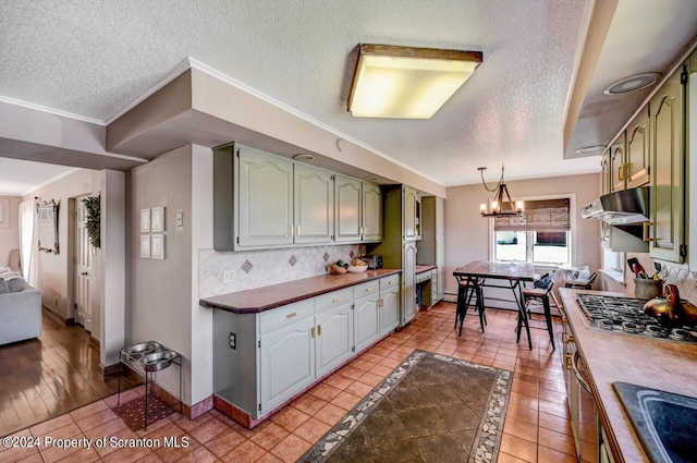 kitchen with a notable chandelier, green cabinets, light tile patterned floors, and tasteful backsplash