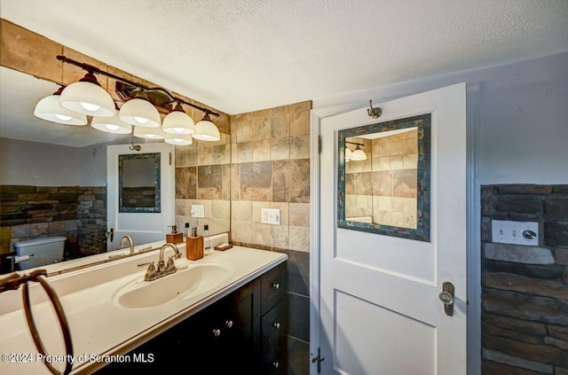 bathroom with vanity, a textured ceiling, and toilet