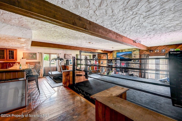 bar with beamed ceiling and wood-type flooring