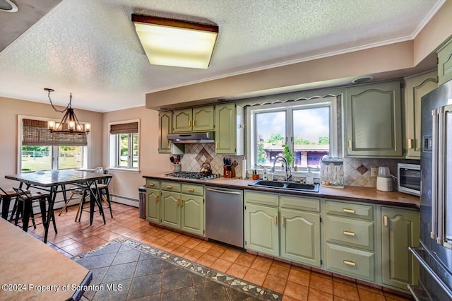 kitchen with sink, green cabinetry, appliances with stainless steel finishes, light tile patterned flooring, and a chandelier