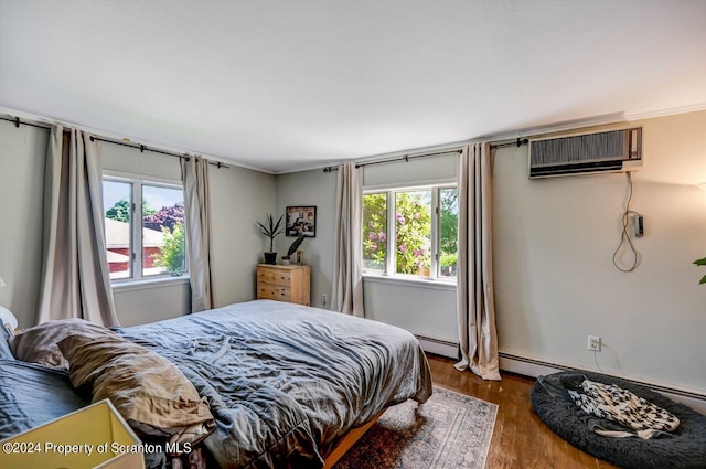 bedroom featuring wood-type flooring, a baseboard radiator, and a wall unit AC