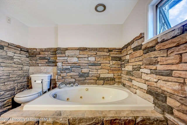 bathroom with a relaxing tiled tub and toilet