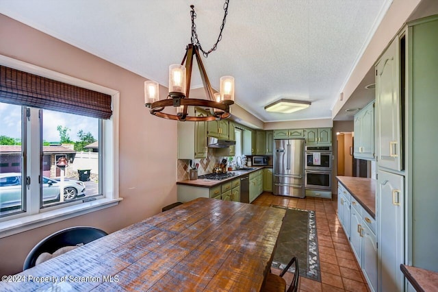 kitchen featuring decorative backsplash, tile patterned floors, stainless steel appliances, sink, and green cabinets