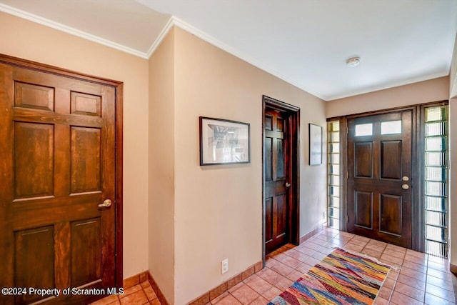 foyer entrance featuring light tile patterned floors and crown molding