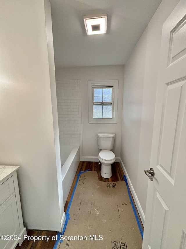 bathroom featuring a washtub, toilet, and vanity