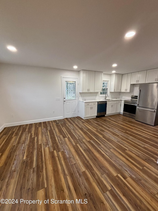 kitchen with sink, white cabinetry, dark wood-type flooring, and appliances with stainless steel finishes