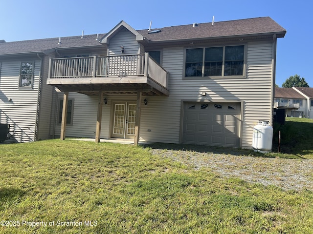 back of house featuring a yard, a balcony, and a garage