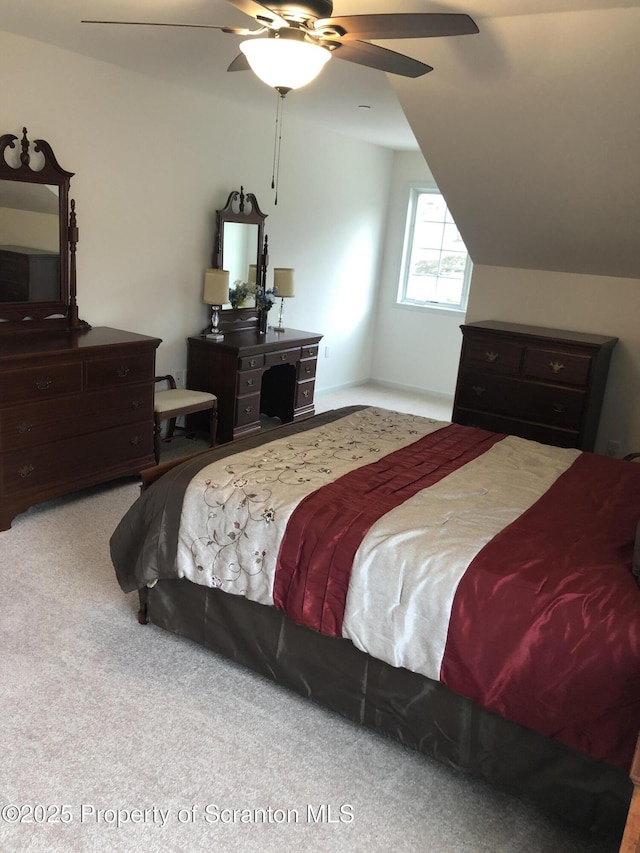 bedroom with ceiling fan, carpet floors, and vaulted ceiling