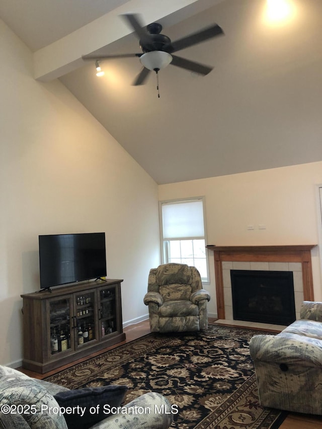 living room featuring a tile fireplace, ceiling fan, and lofted ceiling