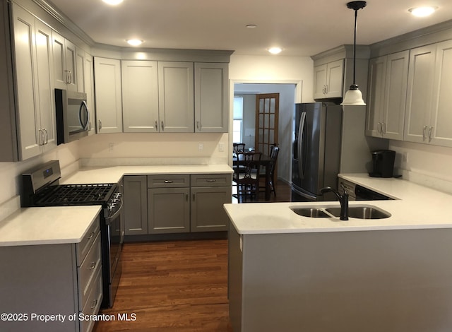 kitchen featuring appliances with stainless steel finishes, gray cabinetry, sink, decorative light fixtures, and dark hardwood / wood-style floors