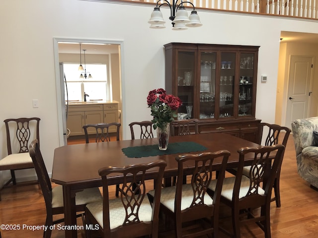 dining area with a chandelier, wood-type flooring, and sink