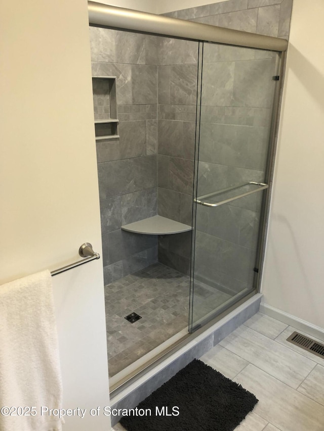 bathroom featuring a shower with door