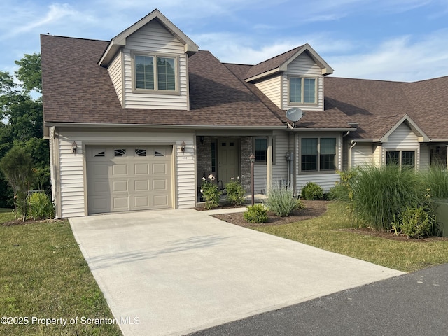 cape cod home with a shingled roof, a front lawn, and concrete driveway