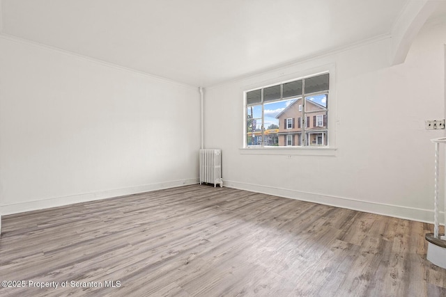 810 Pittston Ave, Scranton, PA 18505 - empty room featuring radiator heating unit, ornamental molding, wood finished floors, and arched walkways