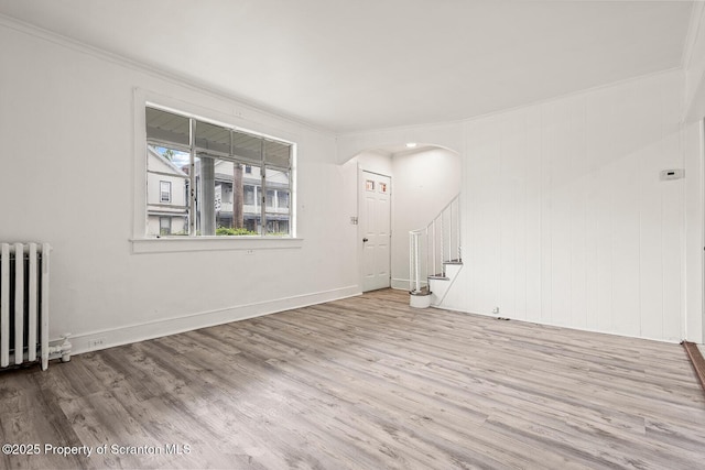 810 Pittston Ave, Scranton, PA 18505 - unfurnished living room with radiator, wood finished floors, crown molding, arched walkways, and stairway