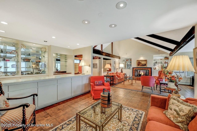 living area with lofted ceiling, a glass covered fireplace, and recessed lighting