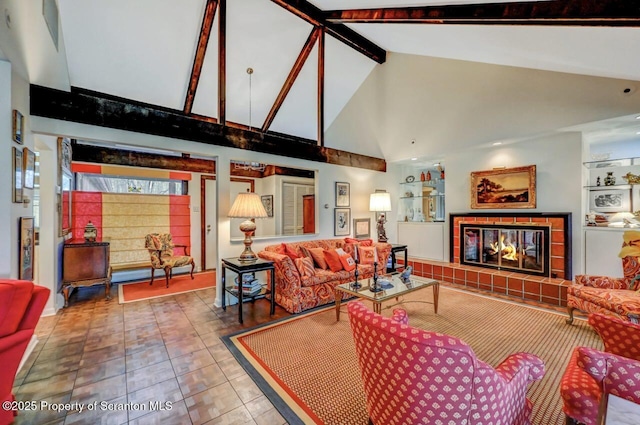 living room with beamed ceiling, a tile fireplace, and high vaulted ceiling