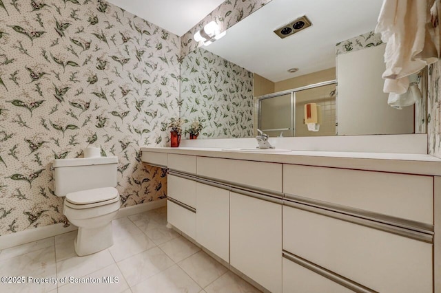 bathroom featuring toilet, wallpapered walls, a stall shower, vanity, and baseboards