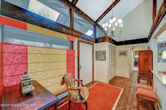 interior space featuring high vaulted ceiling, baseboards, and a notable chandelier