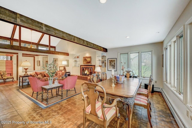 dining area featuring a baseboard heating unit, a glass covered fireplace, lofted ceiling with beams, and recessed lighting