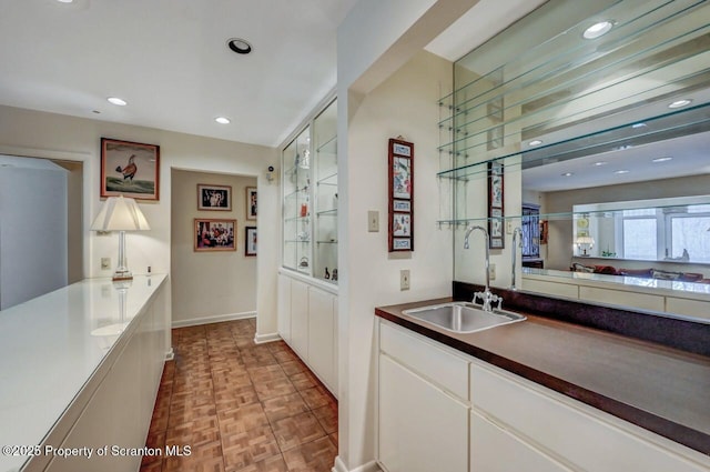 bar with recessed lighting, baseboards, and a sink