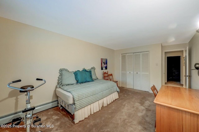 bedroom with baseboard heating, carpet flooring, and a closet