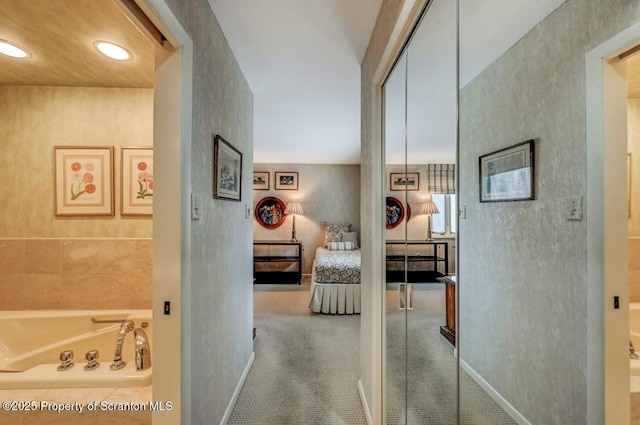 hall with baseboards and recessed lighting