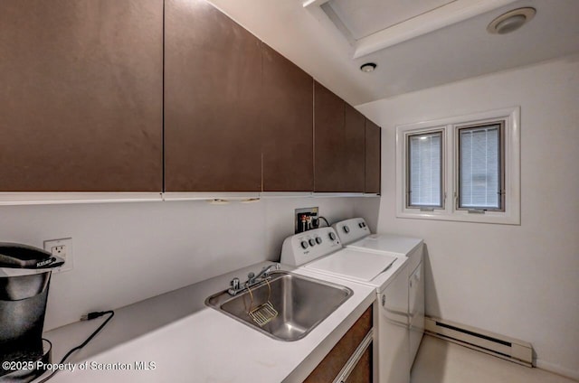 clothes washing area with a sink, washer and dryer, a baseboard radiator, and cabinet space