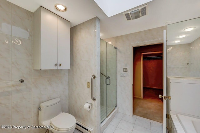 bathroom featuring a shower stall, tile patterned flooring, visible vents, toilet, and tile walls