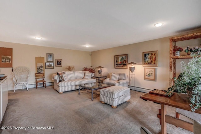 carpeted living room featuring a baseboard heating unit and baseboards