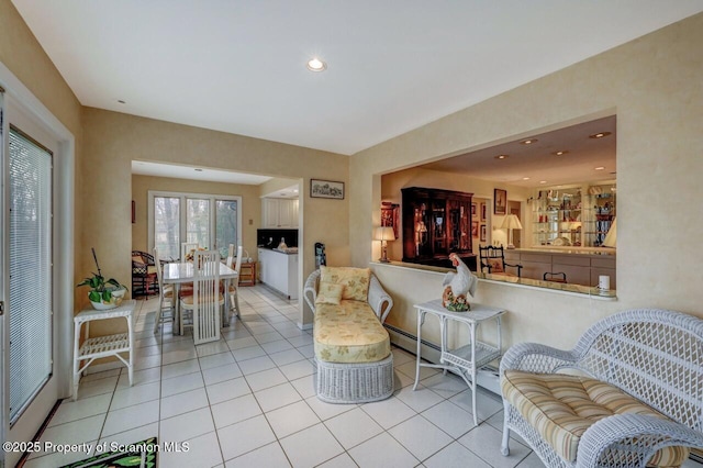 living area with light tile patterned flooring, a baseboard radiator, and recessed lighting