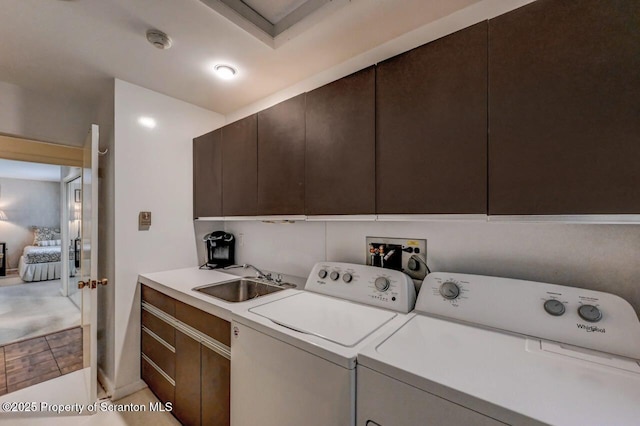 clothes washing area featuring washing machine and clothes dryer, a sink, and laundry area