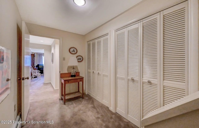 hall with carpet floors and baseboards