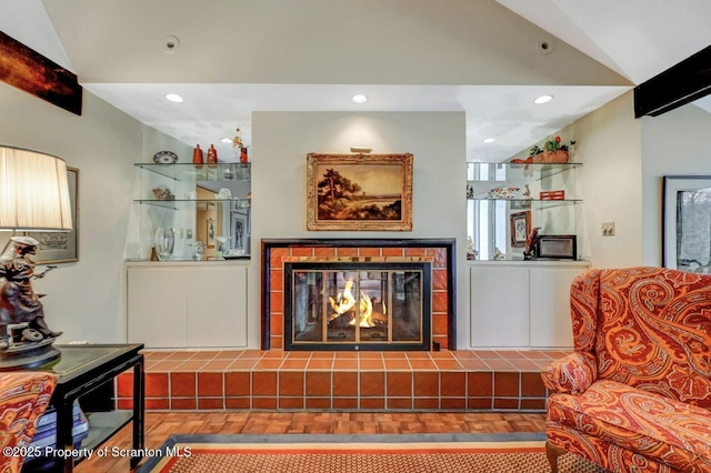 living area with recessed lighting, vaulted ceiling, and a tiled fireplace