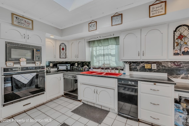 kitchen with tasteful backsplash, sink, black appliances, light tile patterned floors, and white cabinets