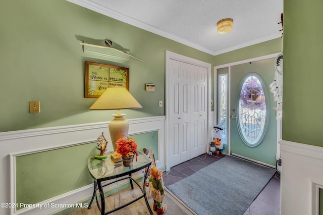 foyer with a textured ceiling and crown molding