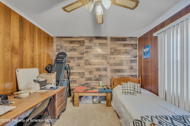 carpeted bedroom with ceiling fan, wood walls, crown molding, and a textured ceiling