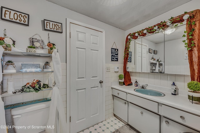 bathroom featuring decorative backsplash, tile patterned floors, vanity, tile walls, and toilet