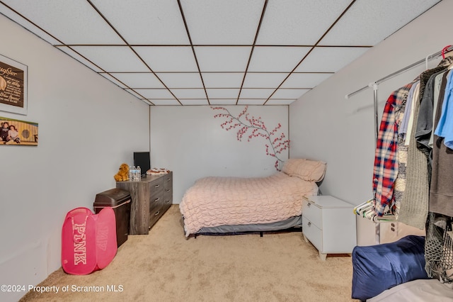 carpeted bedroom featuring a drop ceiling