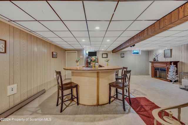 bar with wood walls and a baseboard heating unit