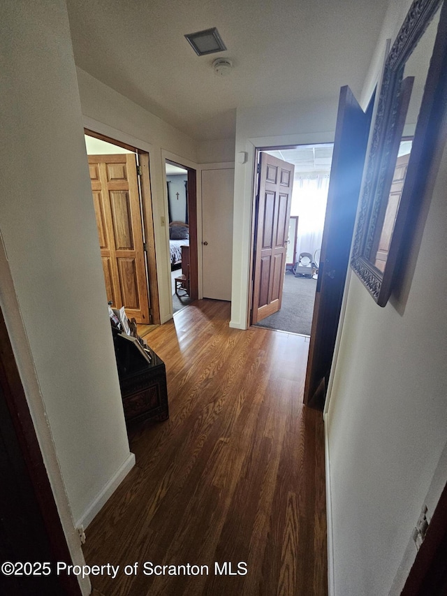 hallway with visible vents and wood finished floors