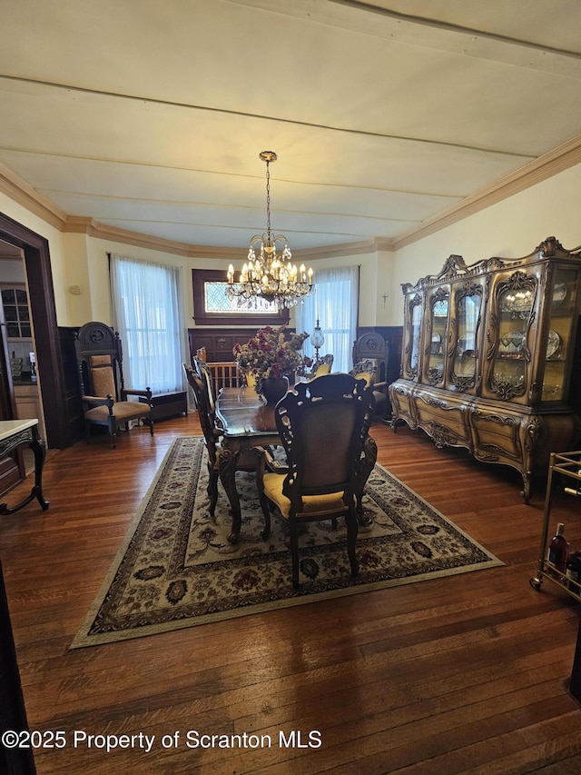 dining room featuring an inviting chandelier, ornamental molding, and wood finished floors