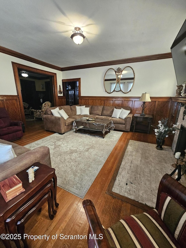 living area with crown molding, wainscoting, and wood finished floors