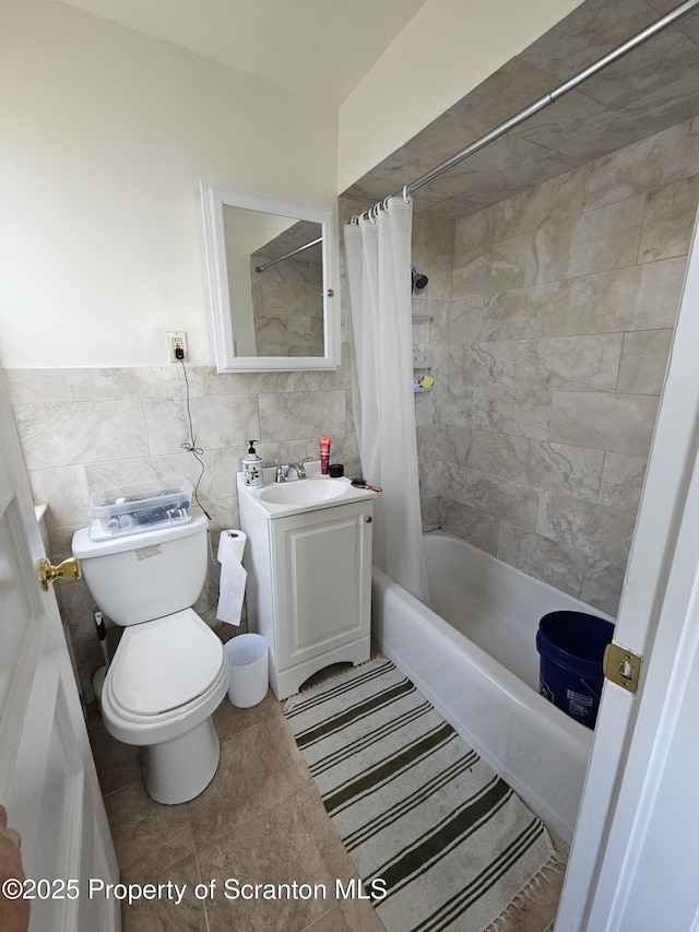 full bath with vanity, shower / tub combo, toilet, and tile walls
