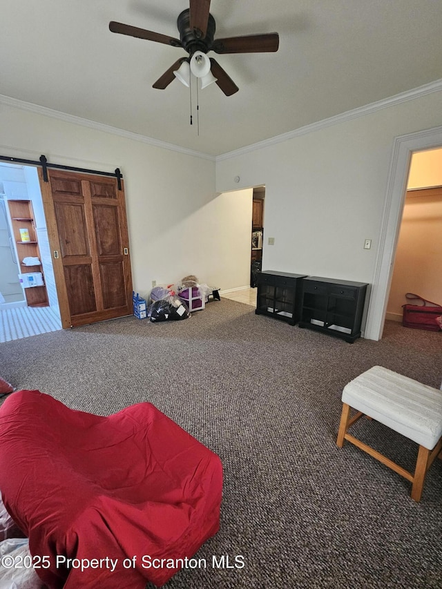 living area featuring crown molding, a ceiling fan, a barn door, and carpet