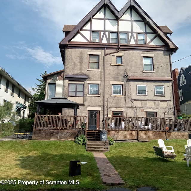 back of property featuring a lawn, a wooden deck, and a gazebo