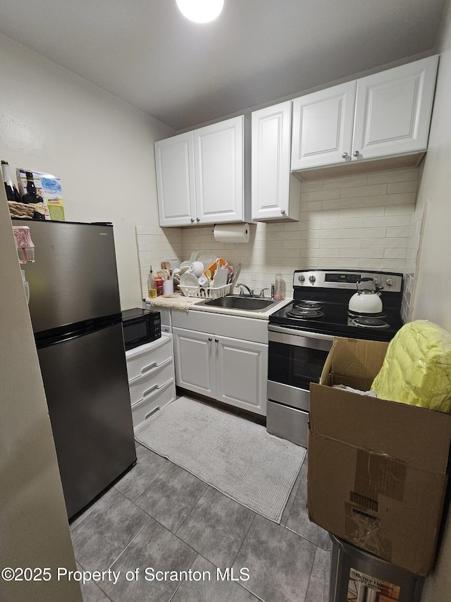 kitchen featuring a sink, appliances with stainless steel finishes, backsplash, and white cabinetry