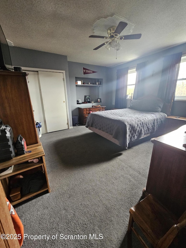 bedroom with a textured ceiling, ceiling fan, carpet, and a closet
