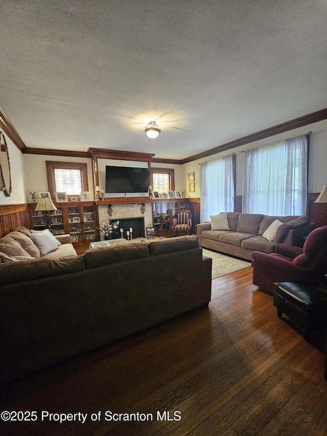 living area featuring ornamental molding, a fireplace, and wood finished floors